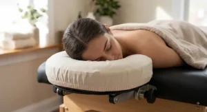 Spa client lying comfortably face down on a soft cushioned headrest protected by a fitted face cradle cover.