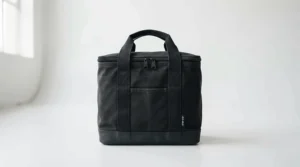 Heavy-duty black massage table carrying bag standing upright in a bright wellness studio.